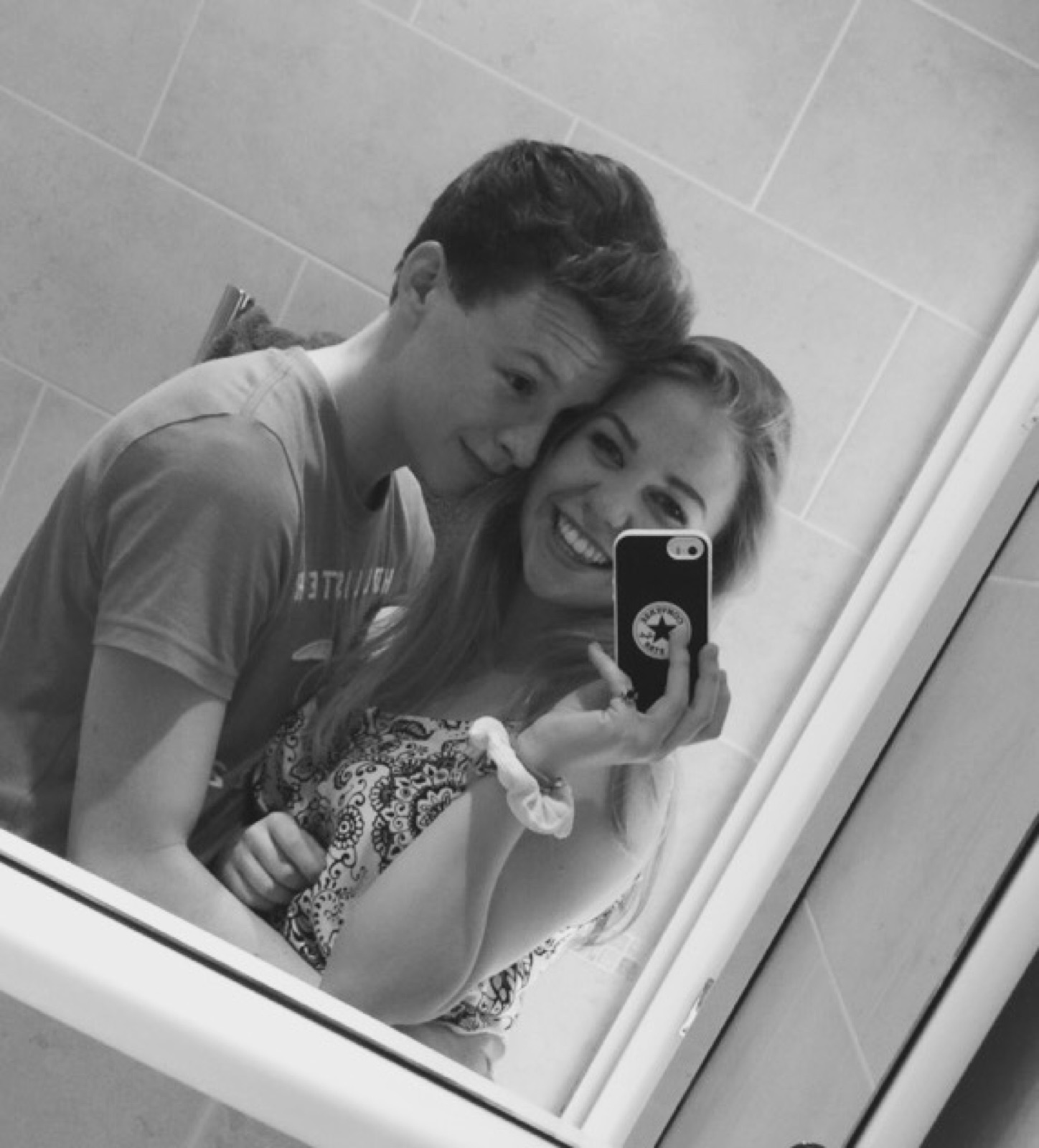 Chloe and Owain smiling in a black-and-white mirror selfie