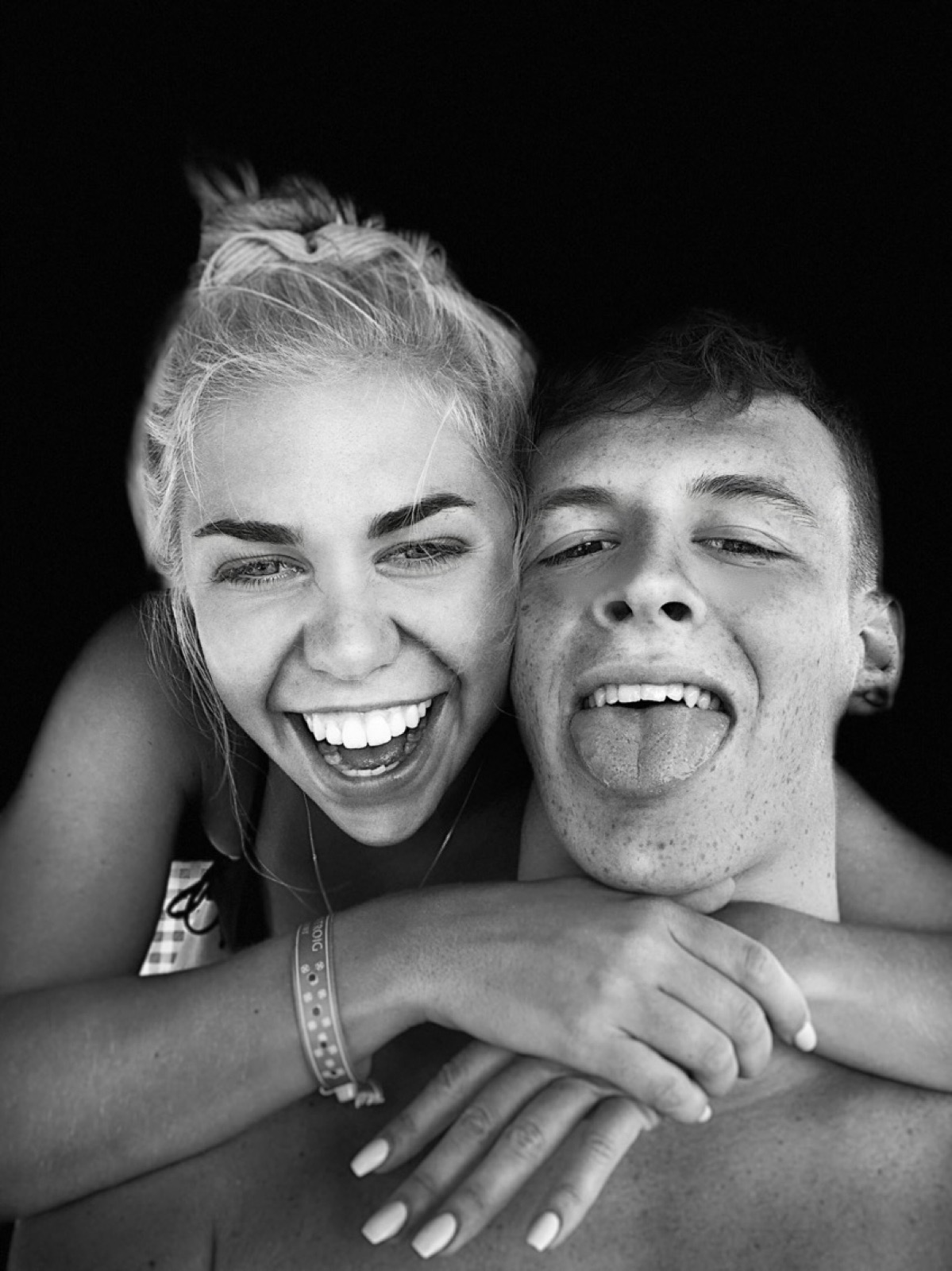 Chloe and Owain laughing cheek to cheek in a playful hug