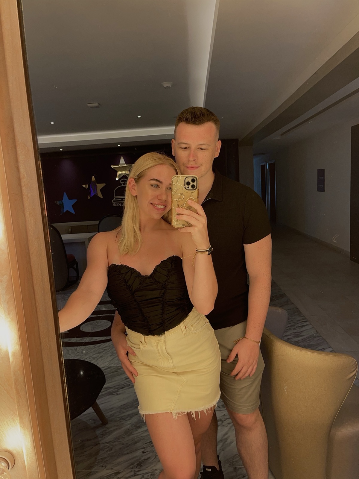 Chloe and Owain taking a mirror selfie in a hotel